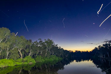 Night-time view from the boat, a long exposure catching the trails of flying bugs.