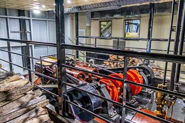 Restored 1907 wood‑fired steam engine aboard the P.S. Australian Star, showing pistons, flywheels, and stacked firewood inside the engine room.