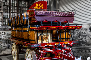 Restored vintage Carlton & United Breweries Clydesdale beer cart with polished wooden barrels, red and gold detailing, and leather seat on display at the Great Aussie Beer Shed.