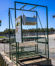Metal‑framed fish trap at Torrumbarry Weir showing suspended hopper and mesh chute used to separate carp from native fish based on swimming behaviour.