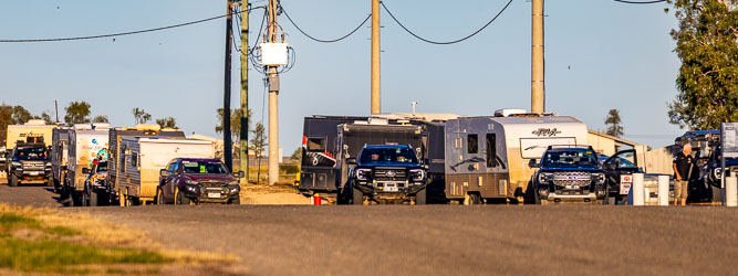 Queue of caravans waiting for Birdsville's only service station to open on a Sunday morning. [9393]