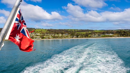 Wake from a ferry as it leaves port, with ship's maritime flag on the left. [4434]