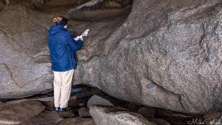 Tour guide in a rock cave checking her notes. [3490]