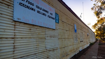 Sign reading "Ice Cream" etc on a rusty corrugated wall.
