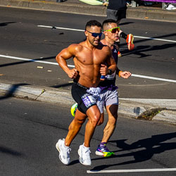 At the 32 km mark, a runner shows off his athletic form as he powers through Taylor Square under the Sydney sun. His focus and energy embody the physical intensity of the marathon’s final stretch. [3927]