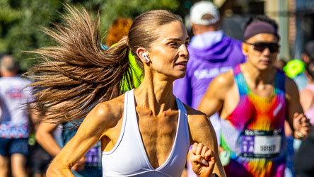 A runner powers through Taylor Square at the 32 km mark, her hair flaring behind her as she locks into rhythm and focus. The sunlight and motion combine to create a portrait of strength and poise in full stride. [3970]
