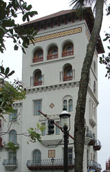 Historic Spanish‑style building in St Augustine, Florida, with arched windows, stucco walls, and palm trees in the foreground.