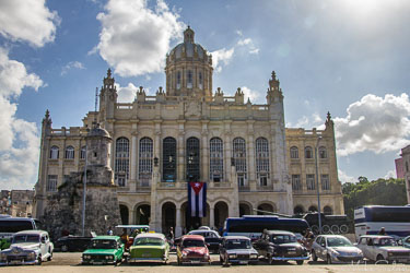 Former Presidential Palace in Havana, Cuba, now Museum of the Revolution, with grand dome, neoclassical façade, Cuban flag, and vintage cars parked in front.