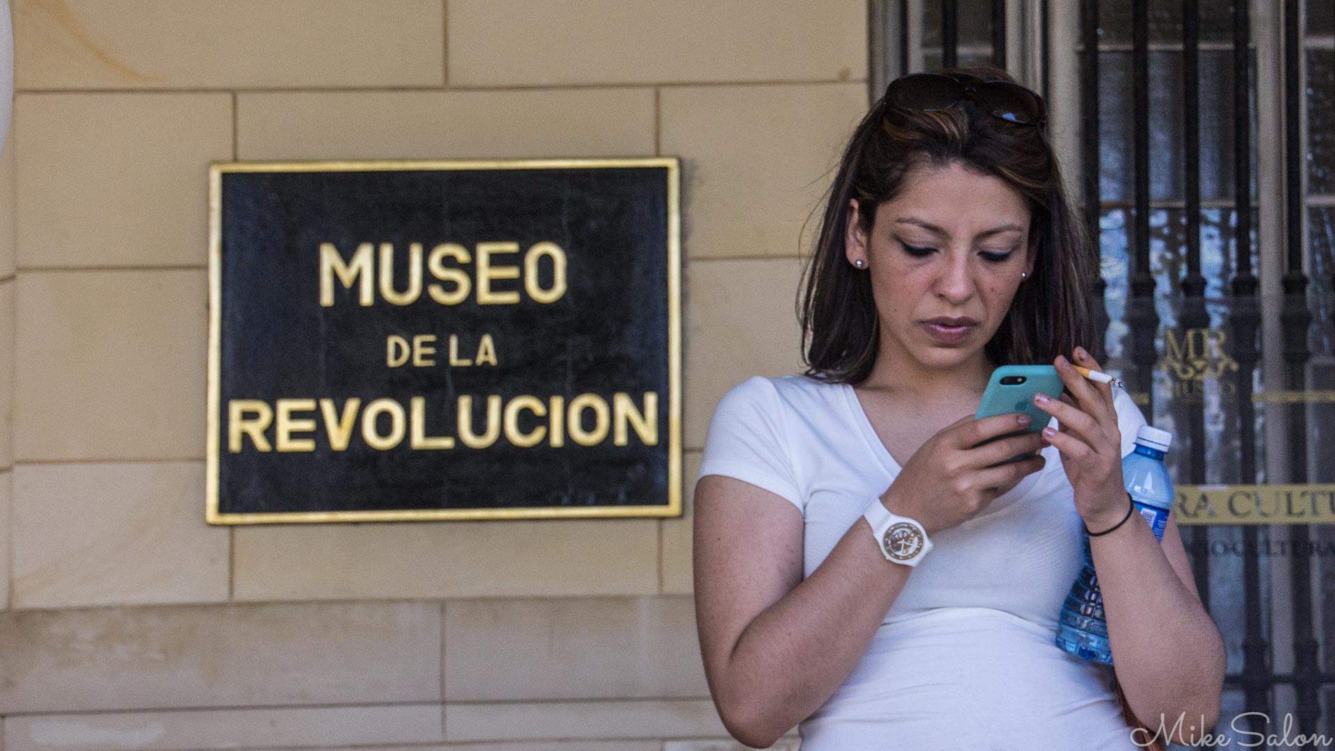 Cuban resident has all the essentials of a modern revolutionary - cigarette, smart-phone & bottled water. Cuban resident has all the essentials of a modern revolutionary - cigarette, smart-phone & bottled water.