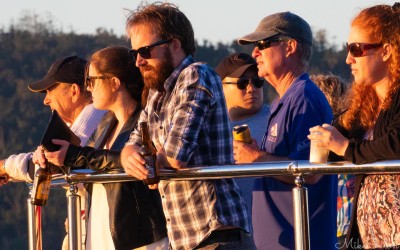 Group of people leaning on a railing at One Tree Hill, Hamilton Island, watching the sunset over the Whitsundays.