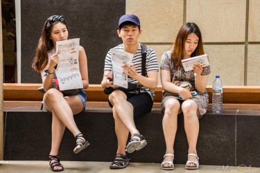 Three visitors sitting on a bench at the Musée d